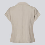 Short-sleeved blazer vest with a notched collar. The BenittaMD Vest features a relaxed, waist-focused fit, side pockets, and a single-button closure – the lightweight fabric creates a modern, effortless look, perfect worn alone or layered for a sharp, fashion-forward style.