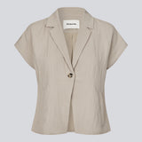 Short-sleeved blazer vest with a notched collar. The BenittaMD Vest features a relaxed, waist-focused fit, side pockets, and a single-button closure – the lightweight fabric creates a modern, effortless look, perfect worn alone or layered for a sharp, fashion-forward style.