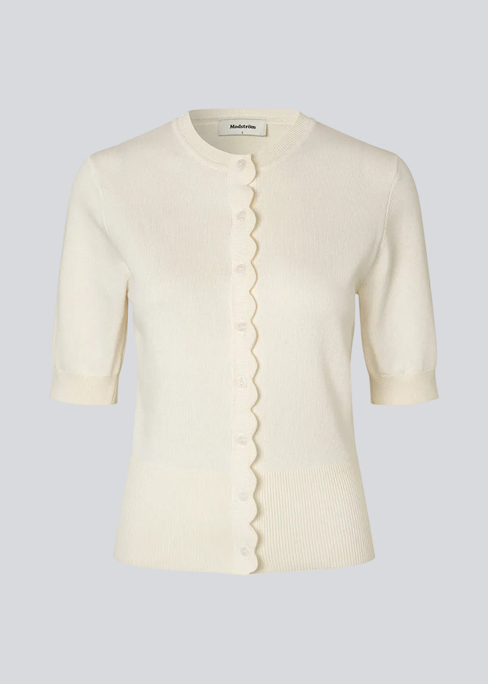Feminine short-sleeved cardigan in lightweight knit. The Bennamd SS Cardigan features classic details such as ribbed trims, a button closure, and a round neckline, with a delicate wavy edge along the button placket for an elegant touch.