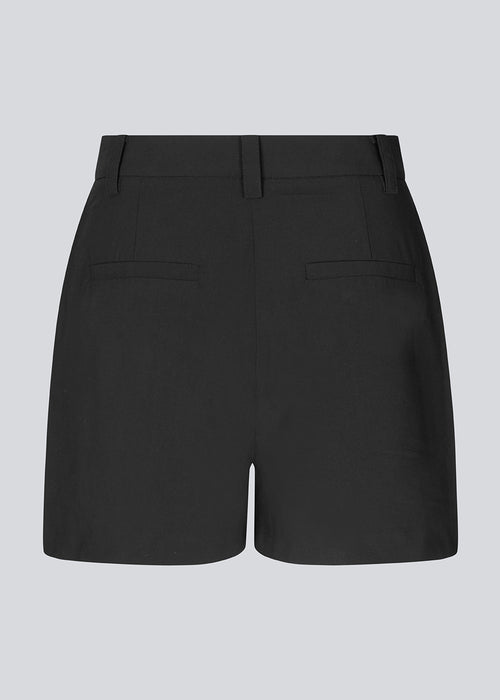 Discover elegance and comfort with our BennyMD High-Waisted Shorts. These black shorts feature a tight fit with discreet side pockets and decorative paspoil pockets on the back. BennyMD shorts come with a zip fly and button closure, along with belt loops for added style.