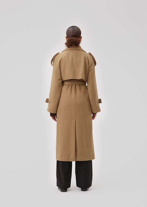 Coat in Dune in trenchcoat style with an oversized silhouette. BorakMD coat is double-breasted with a collar, open yoke, belt at the waist, and a slit in the back. Woolen quality. Lined.