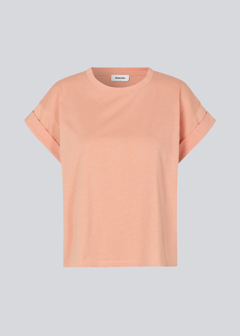 T-shirt in the color Peach Nectar organic cotton with a slightly cropped length. BrazilMD short t-shirt has a rounder neck and rolled-up sleeves. The model is 177 cm and wears a size S/36.