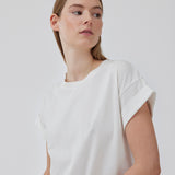 White t-shirt in organic cotton with a slightly cropped length. BrazilMD short t-shirt has a rounder neck and rolled-up sleeves. The model is 177 cm and wears a size S/36.<br>