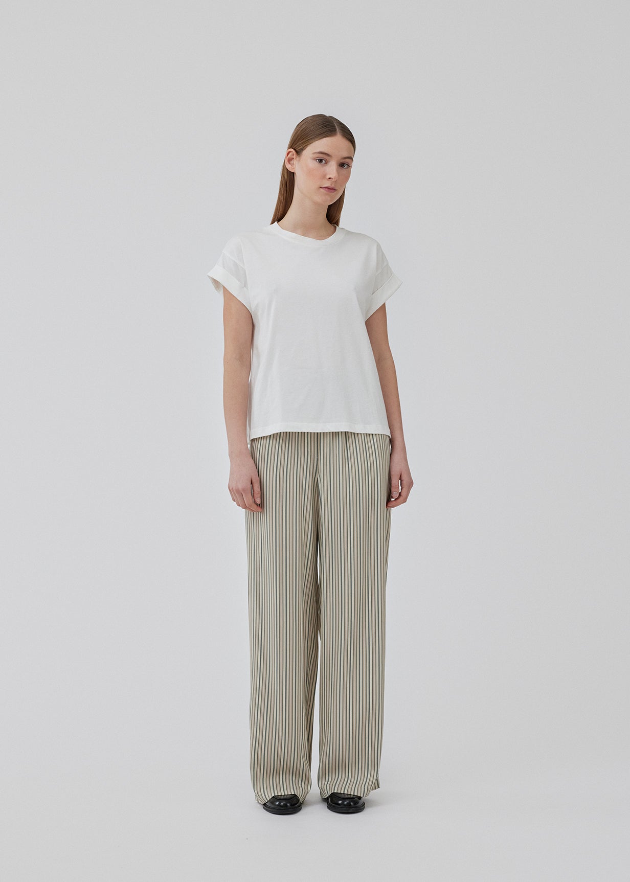 White t-shirt in organic cotton with a slightly cropped length. BrazilMD short t-shirt has a rounder neck and rolled-up sleeves. The model is 177 cm and wears a size S/36.<br>