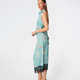 Elegant maxi dress featuring an artistic print and feminine details. Carinamd print dress is crafted from a lightweight, smooth fabric with a high halterneck neckline that fastens at the back of the neck and a self-tie belt at the waist to define the silhouette. The long, flowing fit is finished with a contrasting lace trim at the hem, adding a refined and romantic touch. A standout dress, perfect for summer parties, weddings, and other special occasions.
