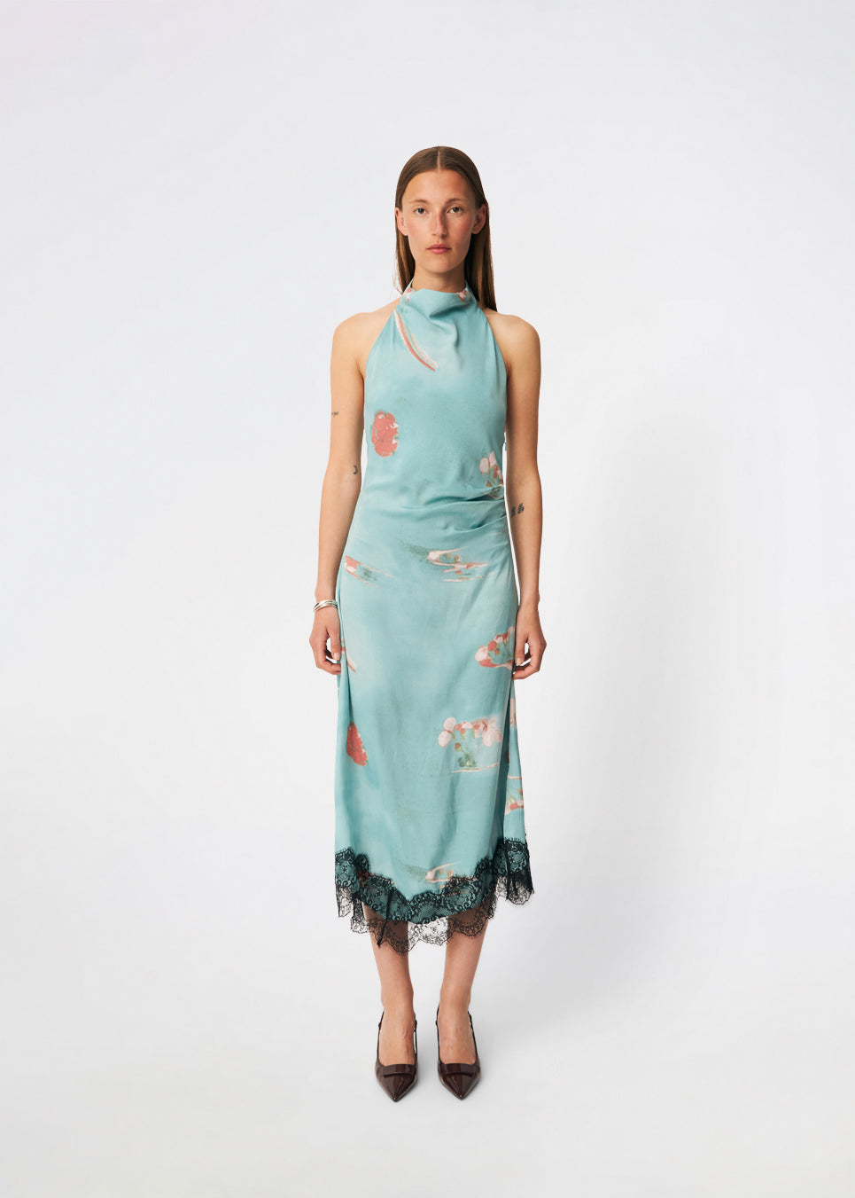 Elegant maxi dress featuring an artistic print and feminine details. Carinamd print dress is crafted from a lightweight, smooth fabric with a high halterneck neckline that fastens at the back of the neck and a self-tie belt at the waist to define the silhouette. The long, flowing fit is finished with a contrasting lace trim at the hem, adding a refined and romantic touch. A standout dress, perfect for summer parties, weddings, and other special occasions.