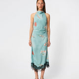 Elegant maxi dress featuring an artistic print and feminine details. Carinamd print dress is crafted from a lightweight, smooth fabric with a high halterneck neckline that fastens at the back of the neck and a self-tie belt at the waist to define the silhouette. The long, flowing fit is finished with a contrasting lace trim at the hem, adding a refined and romantic touch. A standout dress, perfect for summer parties, weddings, and other special occasions.