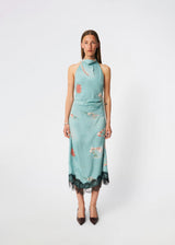 Elegant maxi dress featuring an artistic print and feminine details. Carinamd print dress is crafted from a lightweight, smooth fabric with a high halterneck neckline that fastens at the back of the neck and a self-tie belt at the waist to define the silhouette. The long, flowing fit is finished with a contrasting lace trim at the hem, adding a refined and romantic touch. A standout dress, perfect for summer parties, weddings, and other special occasions.