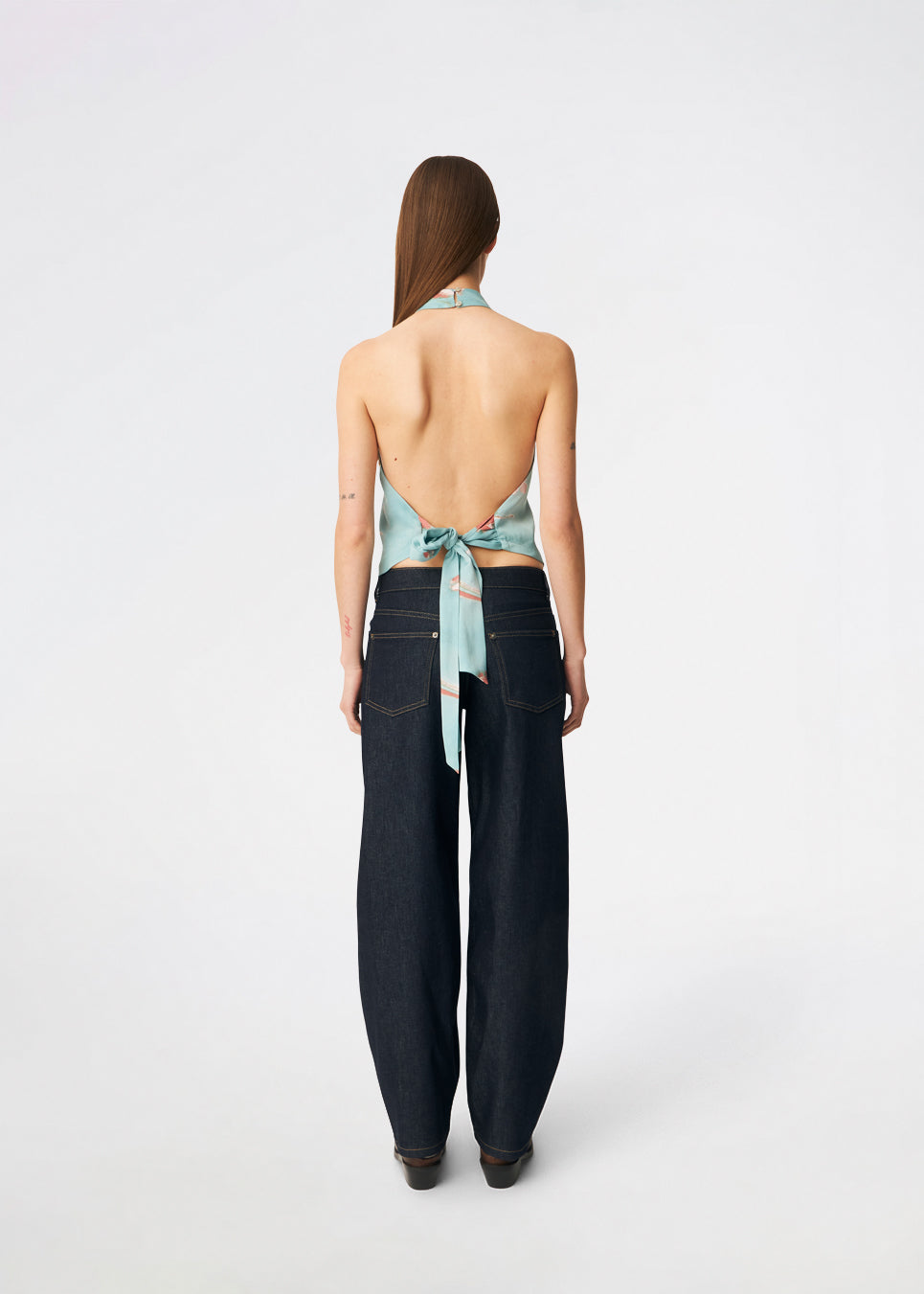 Elegant halterneck top featuring an artistic print and a feminine silhouette. Carinamd print top is crafted from a lightweight, smooth fabric with a high halterneck neckline that fastens at the back of the neck and a tie detail at the back for an adjustable fit. The softly draped design and unique print make it a standout piece for special occasions as well as elevated summer styling.