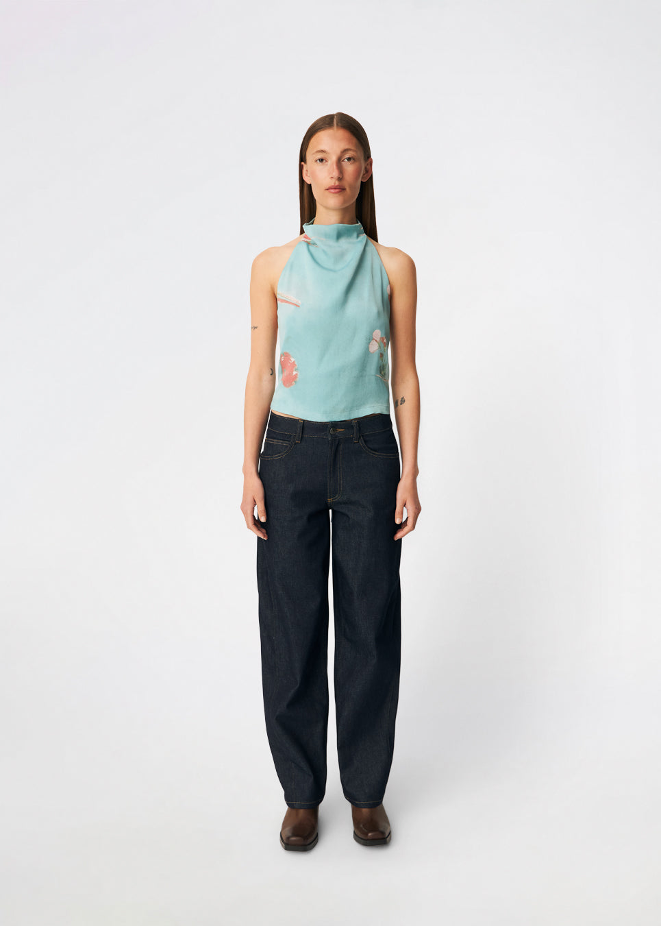 Elegant halterneck top featuring an artistic print and a feminine silhouette. Carinamd print top is crafted from a lightweight, smooth fabric with a high halterneck neckline that fastens at the back of the neck and a tie detail at the back for an adjustable fit. The softly draped design and unique print make it a standout piece for special occasions as well as elevated summer styling.