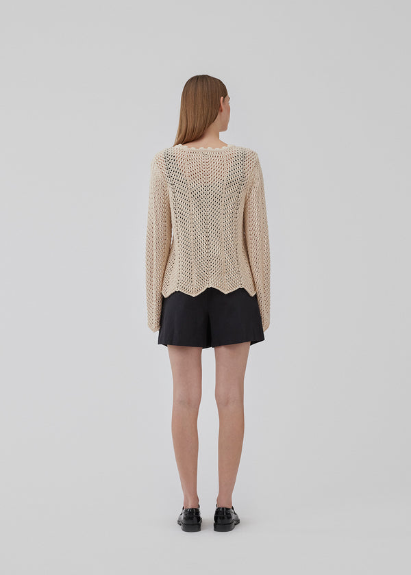 Jumper in beige in crocheted style made from soft organic cotton. CaryMD o-neck has a relaxed fit with a round neck with a wavy hem, long wide sleeves, and detailed finishes. The model is 175 cm and wears a size S/36.