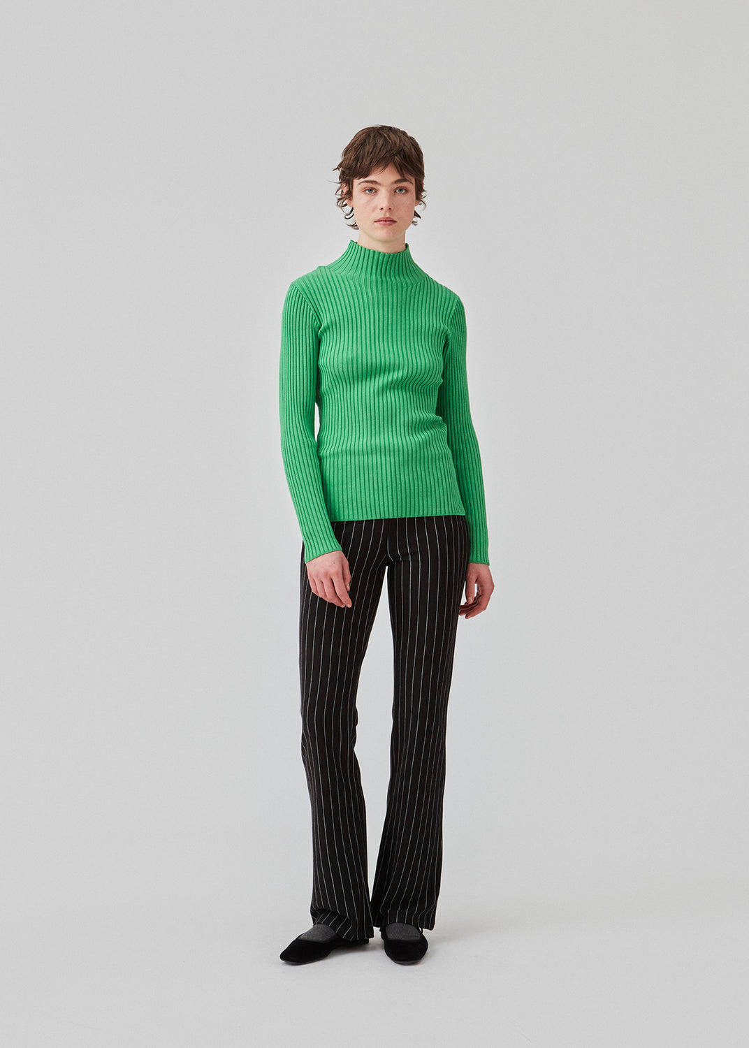 Slim fitted long sleeved top in green in a stretchy rib knit with a high neck. Made from more responsible materials.  The model is 177 cm and wears a size S/36.