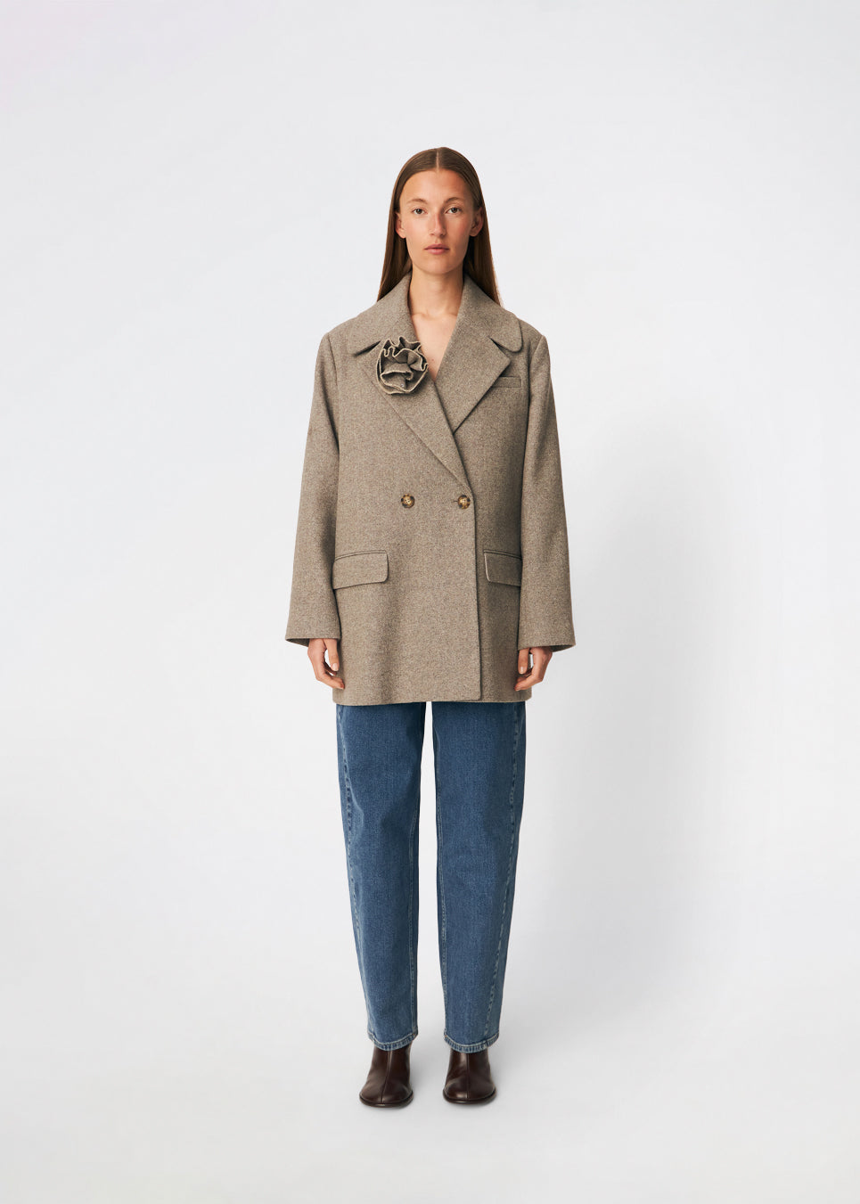 The Cecarmd Jacket is a classic double-breasted jacket with a relaxed oversized fit. Designed with wide lapels, flap pockets, and a detachable flower brooch, it combines timeless tailoring with a feminine decorative detail. Crafted from a soft wool blend, it works perfectly as a transitional jacket or as an elegant layer over knitwear and tailored looks throughout the season.