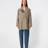 The Cecarmd Jacket is a classic double-breasted jacket with a relaxed oversized fit. Designed with wide lapels, flap pockets, and a detachable flower brooch, it combines timeless tailoring with a feminine decorative detail. Crafted from a soft wool blend, it works perfectly as a transitional jacket or as an elegant layer over knitwear and tailored looks throughout the season.