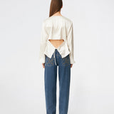 Elegant satin blouse with a feminine and contemporary look. Cianomd top is crafted from a lustrous satin fabric with long sleeves, a boat neckline, and a striking open-back detail finished with delicate tie fastening. A refined wardrobe staple that pairs effortlessly with tailored trousers, denim, or occasion-ready skirts.