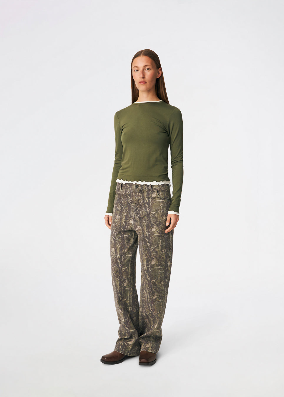 Long-sleeved T-shirt crafted from a soft and comfortable fabric. CiljaMD LS T-shirt features a fitted silhouette with a crew neckline and contrasting trims at the neckline, cuffs, and hem, creating a layered look. The delicate lettuce-edge finish adds a feminine touch, making it perfect to wear on its own or layered under knitwear, shirts, or jackets.