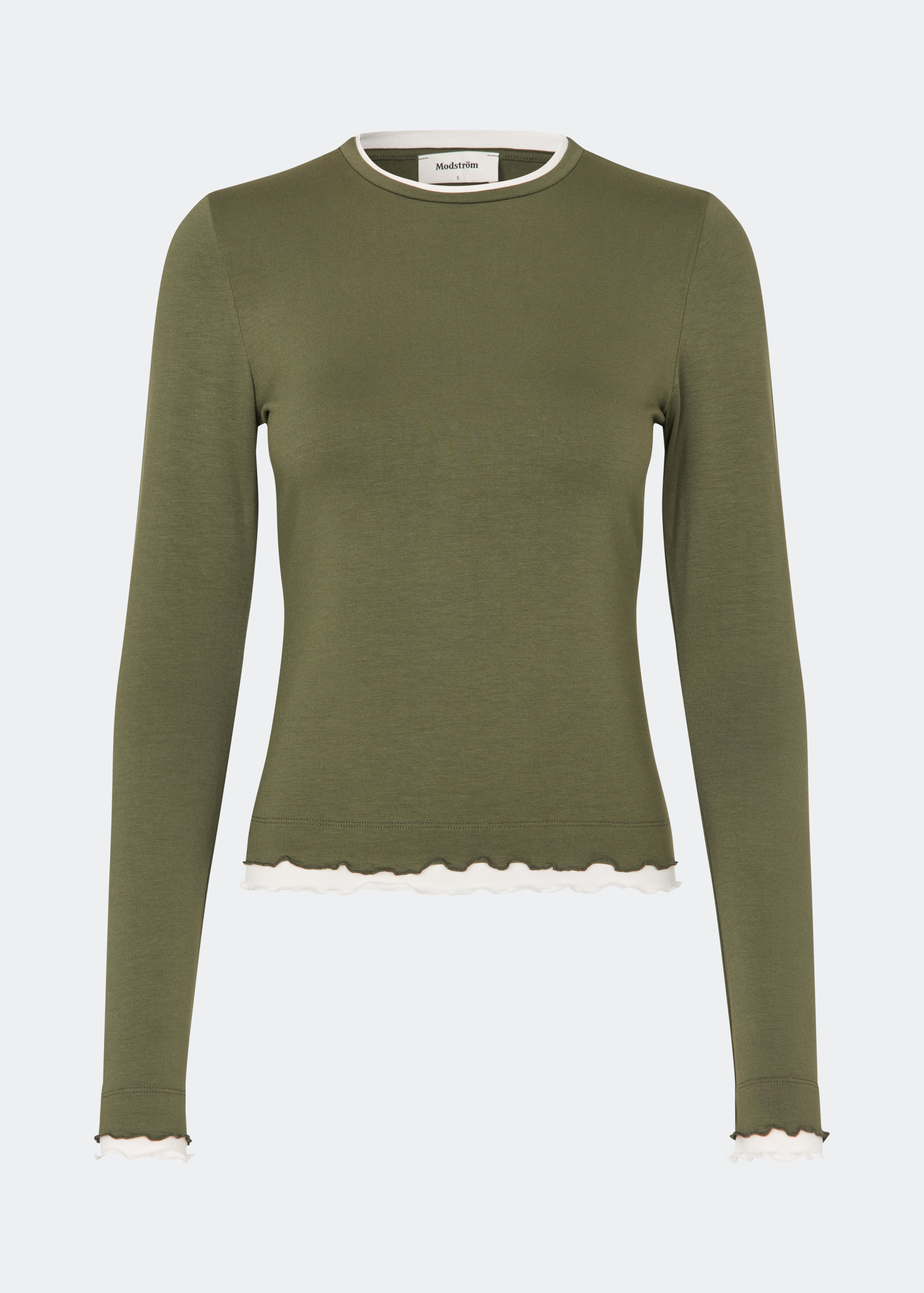 Long-sleeved T-shirt crafted from a soft and comfortable fabric. CiljaMD LS T-shirt features a fitted silhouette with a crew neckline and contrasting trims at the neckline, cuffs, and hem, creating a layered look. The delicate lettuce-edge finish adds a feminine touch, making it perfect to wear on its own or layered under knitwear, shirts, or jackets.