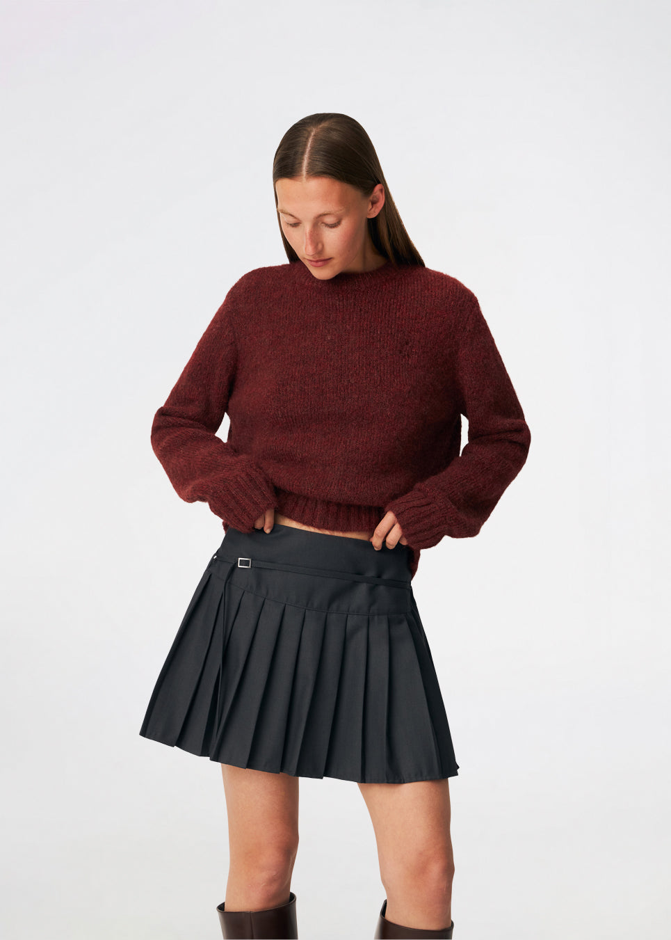 Pleated mini skirt with a modern, preppy aesthetic. Cirkelinemd skirt features a low-rise waist with a wrap-inspired design, decorative strap detail, and crisp pleats that create beautiful movement and volume. The mini length and tailored silhouette make it a versatile piece for both everyday styling and more elevated occasions. Pair it with a shirt, knitwear, or a simple top for a timeless look.