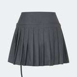 Pleated mini skirt with a modern, preppy aesthetic. Cirkelinemd skirt features a low-rise waist with a wrap-inspired design, decorative strap detail, and crisp pleats that create beautiful movement and volume. The mini length and tailored silhouette make it a versatile piece for both everyday styling and more elevated occasions. Pair it with a shirt, knitwear, or a simple top for a timeless look.