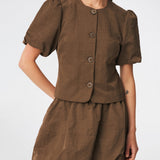 Short-sleeved blazer with a feminine, tailored silhouette. The CirkelMD SS Blazer features a round neckline, short voluminous puff sleeves, and decorative front button closure. Crafted in a lightly textured fabric, it can be worn as both a top and a lightweight jacket, making it ideal for special occasions or an elevated everyday look.