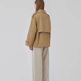 Short trench coat in beige in a cotton quality with concealed buttons down the front. Clara jacket has an oversized silhouette and classic details. Lined.