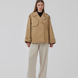 Short trench coat in beige in a cotton quality with concealed buttons down the front. Clara jacket has an oversized silhouette and classic details. Lined.