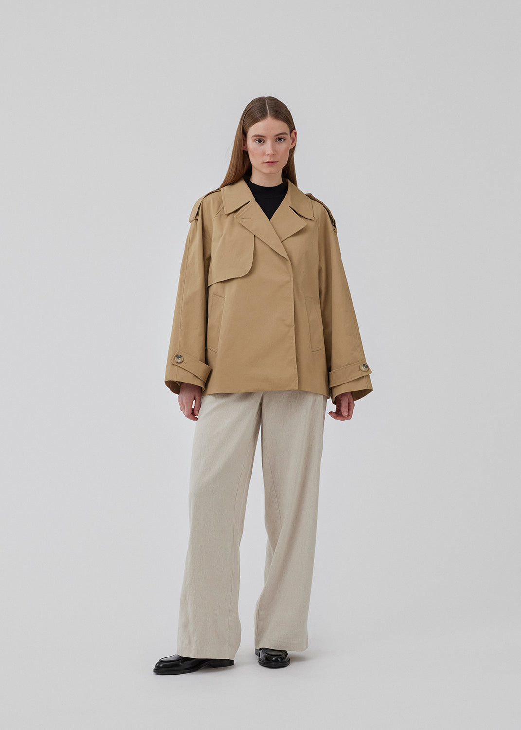 Short trench coat in beige in a cotton quality with concealed buttons down the front. Clara jacket has an oversized silhouette and classic details. Lined.