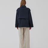 Short trench coat in dar blue in a cotton quality with concealed buttons down the front. Clara jacket has an oversized silhouette and classic details. Lined.