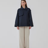 Short trench coat in dar blue in a cotton quality with concealed buttons down the front. Clara jacket has an oversized silhouette and classic details. Lined.