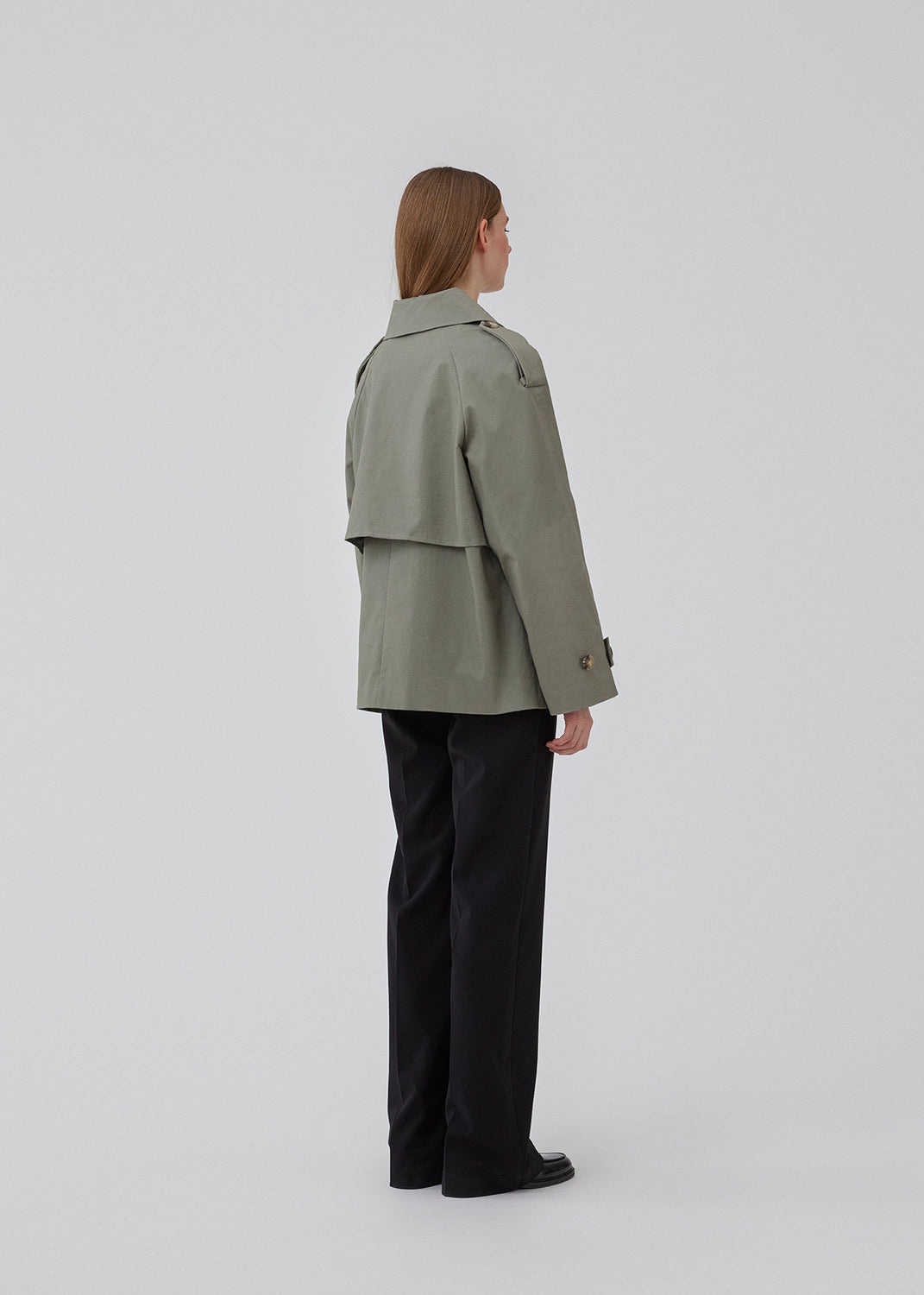 Short trench coat in soft green in a cotton quality with concealed buttons down the front. Clara jacket has an oversized silhouette and classic details. Lined. 