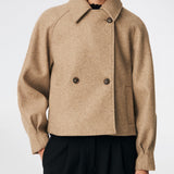 Short jacket with a timeless, sophisticated aesthetic. Cleamd jacket features a relaxed, slightly boxy silhouette with a double-breasted button closure, classic collar, and raglan sleeves for a soft and comfortable fit. Discreet side pockets and clean lines enhance the minimalist design, while the cropped length makes it perfect for both everyday wear and more polished looks.