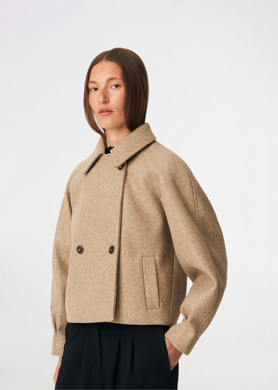 Short jacket with a timeless, sophisticated aesthetic. Cleamd jacket features a relaxed, slightly boxy silhouette with a double-breasted button closure, classic collar, and raglan sleeves for a soft and comfortable fit. Discreet side pockets and clean lines enhance the minimalist design, while the cropped length makes it perfect for both everyday wear and more polished looks.