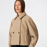 Short jacket with a timeless, sophisticated aesthetic. Cleamd jacket features a relaxed, slightly boxy silhouette with a double-breasted button closure, classic collar, and raglan sleeves for a soft and comfortable fit. Discreet side pockets and clean lines enhance the minimalist design, while the cropped length makes it perfect for both everyday wear and more polished looks.