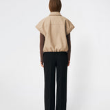 Short vest with a modern, relaxed aesthetic. Cleamd vest features a boxy silhouette with short, wide sleeves, a classic collar, and snap button closure at the front. Discreet front pockets and an elasticated hem create a soft, rounded shape and a comfortable fit. Perfect for layering over knitwear, shirts, or dresses during the transitional seasons.