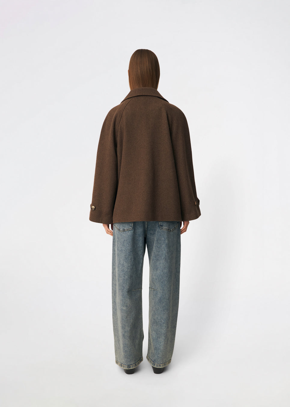 Short double-breasted wool-blend jacket with a wide lapel collar, buttoned cuff straps and raglan sleeves that create a rounded shoulder line. Wear it with denim or a fluid skirt. The model is 175 cm tall and is wearing a size S/36.