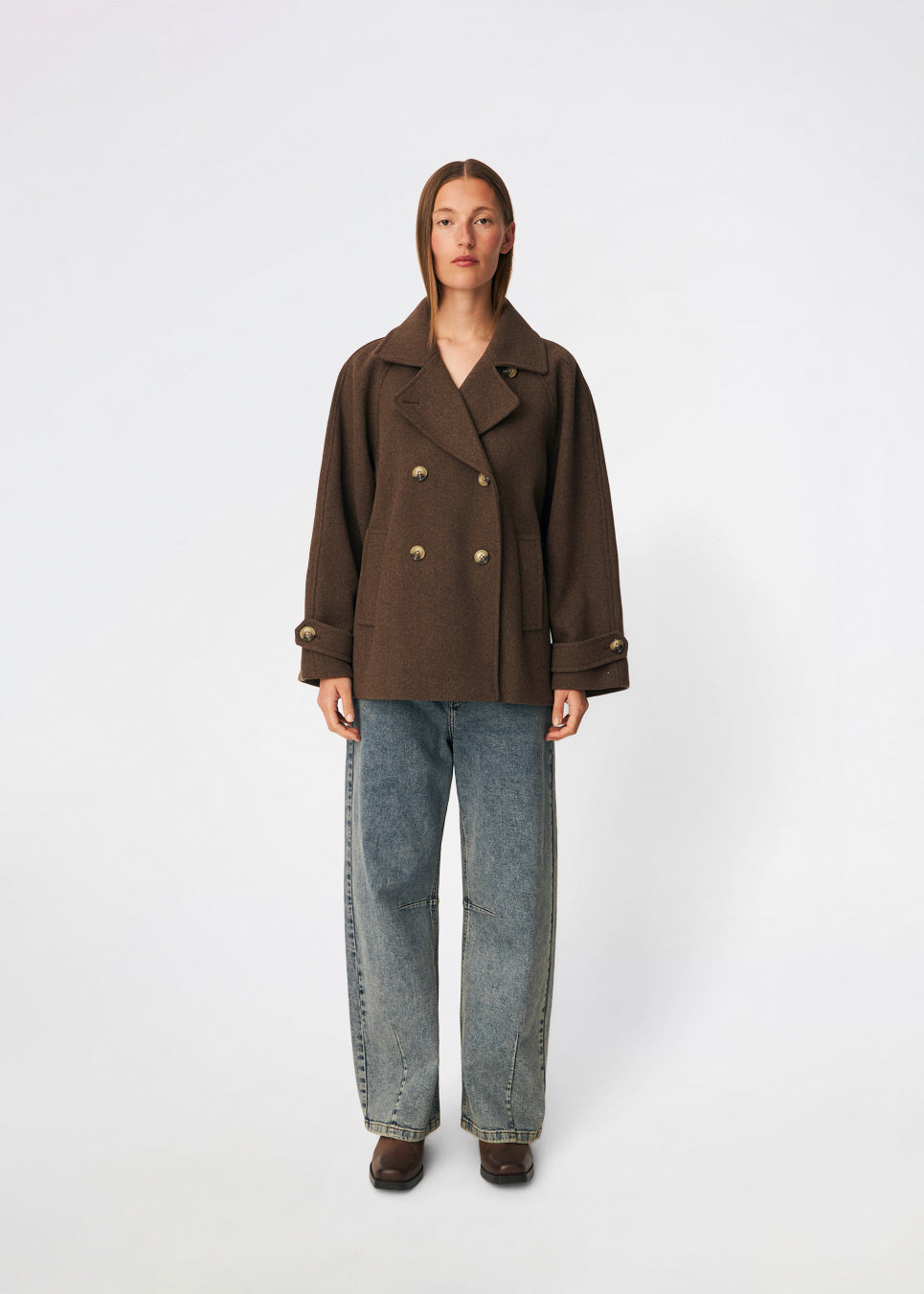 Short double-breasted wool-blend jacket with a wide lapel collar, buttoned cuff straps and raglan sleeves that create a rounded shoulder line. Wear it with denim or a fluid skirt. The model is 175 cm tall and is wearing a size S/36.