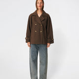Short double-breasted wool-blend jacket with a wide lapel collar, buttoned cuff straps and raglan sleeves that create a rounded shoulder line. Wear it with denim or a fluid skirt. The model is 175 cm tall and is wearing a size S/36.