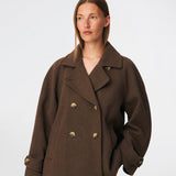 Short double-breasted wool-blend jacket with a wide lapel collar, buttoned cuff straps and raglan sleeves that create a rounded shoulder line. Wear it with denim or a fluid skirt. The model is 175 cm tall and is wearing a size S/36.