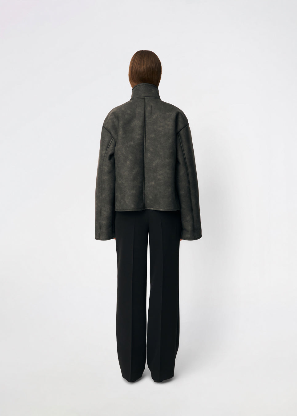 Short faux shearling jacket with a modern, timeless aesthetic. Coralinemd jacket features a relaxed silhouette with a high stand collar, front button closure, and decorative seam detailing that enhances its classic design. Soft teddy trims at the cuffs add warmth and contrast, while the slightly oversized fit makes it perfect for layering throughout the colder months.