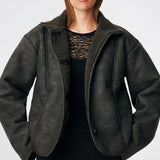Short faux shearling jacket with a modern, timeless aesthetic. Coralinemd jacket features a relaxed silhouette with a high stand collar, front button closure, and decorative seam detailing that enhances its classic design. Soft teddy trims at the cuffs add warmth and contrast, while the slightly oversized fit makes it perfect for layering throughout the colder months.