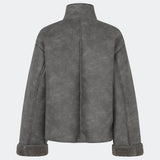 Short faux shearling jacket with a modern, timeless aesthetic. Coralinemd jacket features a relaxed silhouette with a high stand collar, front button closure, and decorative seam detailing that enhances its classic design. Soft teddy trims at the cuffs add warmth and contrast, while the slightly oversized fit makes it perfect for layering throughout the colder months.
