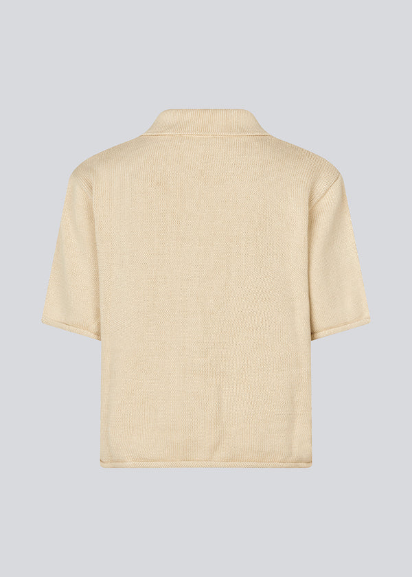 Knitted cardigan with short sleeves. CorbinMD cardigan has a Shirt collar and a button closure in front.