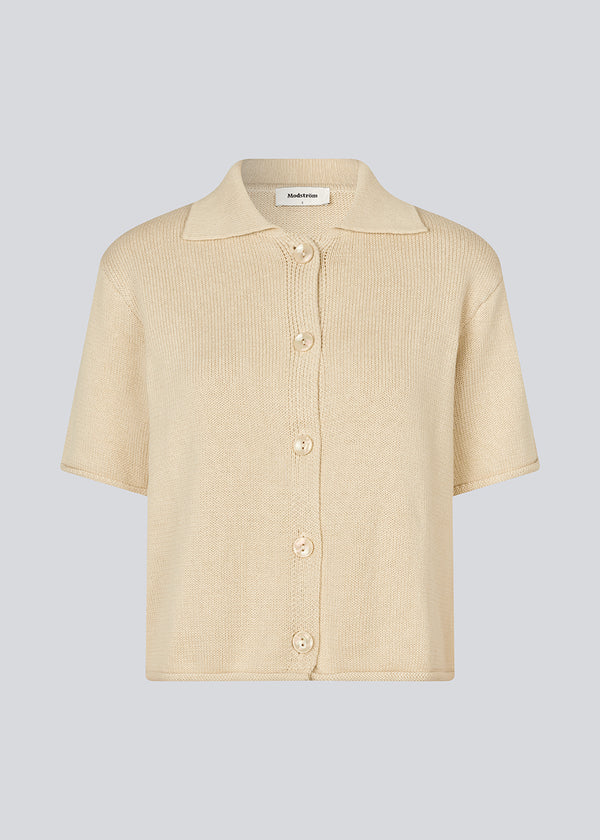 Knitted cardigan with short sleeves. CorbinMD cardigan has a Shirt collar and a button closure in front.