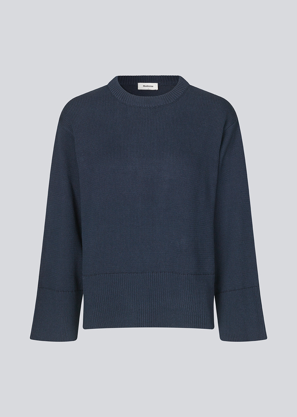 Fine-knitted oversize jumper knitted from cotton in navy. CorbinMD o-neck has ribbed round neckline, long wide sleeves, and wide ribbing at cuffs and hem.  The model is 177 cm and wears a size S/36.