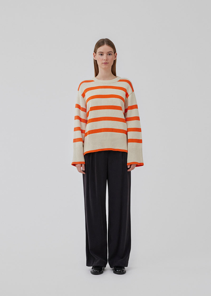 Fine-knitted oversized jumper knitted from cotton in beige with red stripes. CorbinMD stripe o-neck has ribbed round neckline, long wide sleeves, and wide ribbing at cuffs and hem.