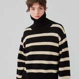 Fine-knitted oversized jumper knitted from cotton in black with beige stripes. CorbinMD stripe t-neck has a ribbed rollneck, long wide sleeves, and wide ribbing at cuffs and hem.  The model is 177 cm and wears a size S/36.
