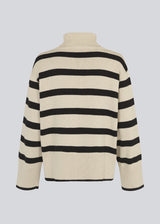 Fine-knitted oversized jumper knitted from cotton in beige with black stripes. CorbinMD stripe t-neck has a ribbed rollneck, long wide sleeves, and wide ribbing at cuffs and hem. 