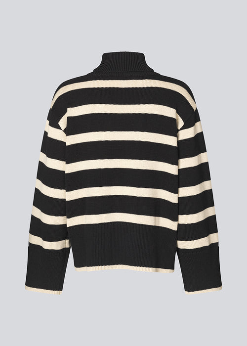 Fine-knitted oversized jumper knitted from cotton in black with beige stripes. CorbinMD stripe t-neck has a ribbed rollneck, long wide sleeves, and wide ribbing at cuffs and hem.  The model is 177 cm and wears a size S/36.