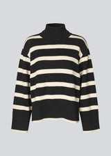 Fine-knitted oversized jumper knitted from cotton in black with beige stripes. CorbinMD stripe t-neck has a ribbed rollneck, long wide sleeves, and wide ribbing at cuffs and hem.  The model is 177 cm and wears a size S/36.