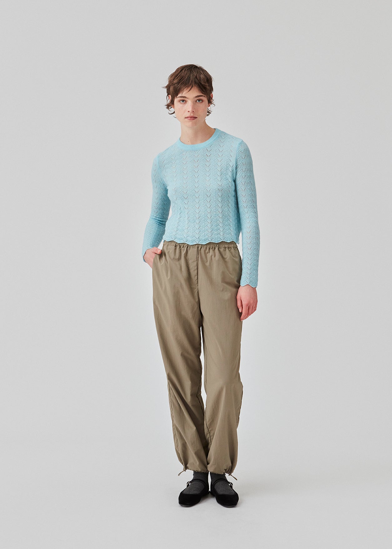 Knitted top in light blue with eyelet pattern in a light quality with wool. CordellMD short o-neck has a relaxed and cropped fit with long sleeves with wavy trims. The model is 175 cm and wears a size